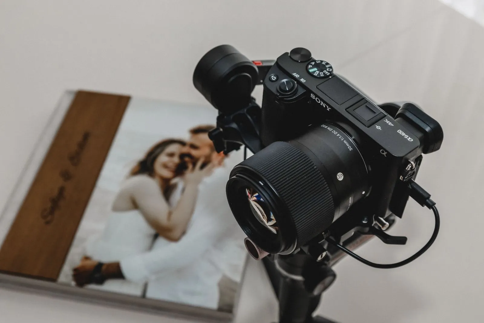 High-quality camera on tripod next to wedding photo album, ideal for photography shoots.